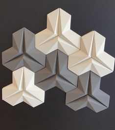 several white origami pieces are arranged in the shape of hexagons