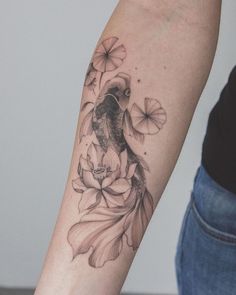 a woman's arm with flowers and a bird tattoo on the left side of her arm