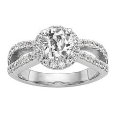 a white gold ring with an oval cut diamond surrounded by pave set round diamonds