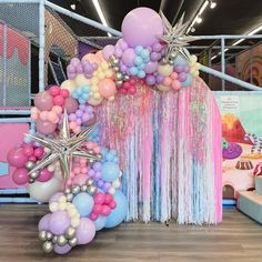 balloons and streamers are on display at a birthday party in an indoor space with a starfish theme