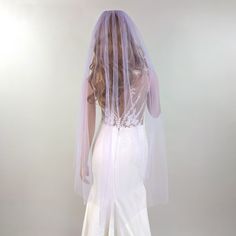 the back of a bride's dress with a veil on her head