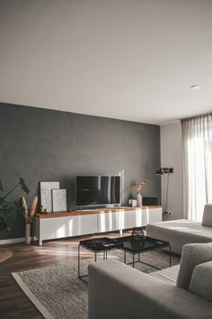 a living room with grey walls and white furniture