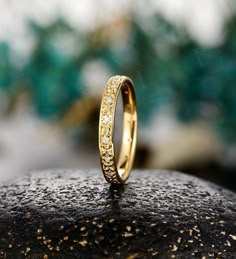 a close up view of a wedding ring on top of a rock