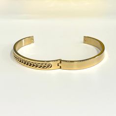 Bring home this magnificent bangle bracelet. Featuring a polished curb chain inlay design this bracelet is made from stainless steel. This is a seriously pretty bangle that is easy way to dress up any outfit, it makes a beautiful gift or a special treat for yourself.- Metal: Stainless Steel.- Plating: 18k Gold plated.- Inner Diameter: 64 mm.- Width: Aprox. 8 mm.- Clasp: Snap Closure.- Circumference Inches: 7.85 Ships in a Balara Gift Pouch.Available in Gold.SKU# B1781 Gold Stainless Steel Bangle, Tarnish Resistant, Tarnish Resistant Stainless Steel Gold Bangle, Elegant Stainless Steel Cuban Link Jewelry, Elegant Metal Cuban Link Bracelet With Curb Chain, Luxury Metal Bangle Chain Bracelet, Luxury Stainless Steel Cuff Bracelet, Tarnish Resistant, Elegant Stainless Steel Jewelry With Curb Chain, Elegant Stainless Steel Curb Chain Jewelry, Adjustable Gold Metal Bracelet With Curb Chain