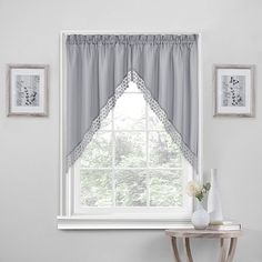 the window is decorated with white and gray curtains