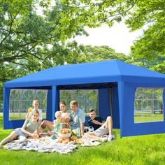 a group of people sitting in front of a blue tent