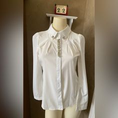 Menghui Fashion Crystal Jewelry Rhinestone Lapel Button Down Shirt White Blouse Women’s Size S. Tag L, But Fits Size S. Brand New With Original Tag. Price Is Firm. Nice For Holiday Pictures. Nice Shape . Measurements (Approximate While Lying Flat - See Attached Photos). Please Double Check The Measurements As There Are No Returns. No Holds. Smoke Free Home. Please See My Pictures For Details As They Are Part Of My Description. Thank You For Looking. Long Sleeve Shirt With Rhinestones For Party, Long Sleeve Rhinestone Party Shirt, Long Sleeve Party Shirt With Rhinestones, Fitted Collared Tops With Pearl Buttons, Formal Fitted Tops With Pearl Buttons, Elegant Long Sleeve Shirt With Rhinestones, Elegant Workwear Tops With Embellished Collar, White Blouse With Embellished Collar For Work, Elegant Tops With Embellished Collar For Work