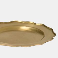 an oval brass platter with scalloped edges