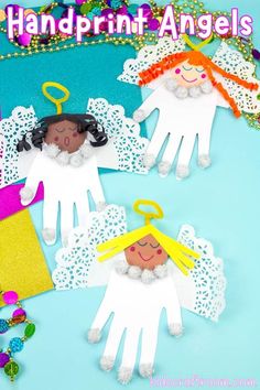 handprint angels made out of paper on a blue background with beads and other crafting supplies