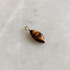 ITEM DESCRIPTION: >>The pendant is made from Solid 14K Yellow Gold. Gemstone used is absolutely natural and ethically sourced. >>Natural Tiger Eye in cabochon marquise shape with bezel setting is studded on it with utmost precision. >>This is a minimalist design and is absolutely hassle-free and everyday jewelry. Gem: Tiger Eye Gem size: 11x21 mm Marquise Gem weight: 9.55 carats Gold purity: 14K (58.33% approx.) Gold weight: 0.56 grams Gross weight: 2.46 grams The Gold purity is guaranteed and i 14k Gold Gemstones With Bezel Setting For Gift, 14k Gold Amber Jewelry With Polished Finish, Polished 14k Gold Amber Jewelry, Fine Jewelry In 14k Gold, Brown, Fine Jewelry In 14k Gold With Brown Color, Fine Brown 14k Gold Jewelry, Gold Cabochon Teardrop Pendant Jewelry, Gold Cabochon Teardrop Pendant, Teardrop Pendant Jewelry With Bezel Setting