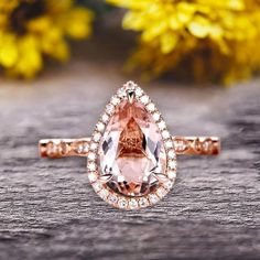 an engagement ring with a pear shaped morganite surrounded by diamonds