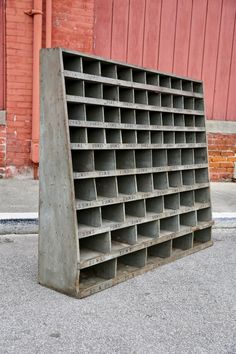 an old metal shelf sitting in front of a red building