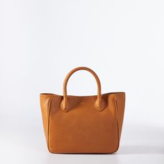 Crafted by Italian leather artisans in a family owned factory in Florence, the Elisabetta midi handbag is beautifully made with gorgeous Italian leather that only gets better with age. A mid-sized version of our iconic Elisabetta, this timeless silhouette is both simple and elegant, polished enough for formal occasions yet relaxed enough for everyday use. Make it yours with a classic foil debossed monogram.    12"w x 5"d x 10.5"h  Italian leather with a linen lined interior.  Made in Italy.  Mon Cognac Leather Bag With Round Handle, Leather Satchel With Round Handle For Everyday Use, Chic Brown Satchel With Rolled Handles, Timeless Bags With Round Handle For Daily Use, Timeless Everyday Shoulder Bag With Rolled Handles, Classic Shoulder Bag With Top Handle And Rolled Handles, Classic Satchel With Rolled Handles For Shopping, Timeless Bags For Daily Use With Round Handle, Top Handle Satchel With Smooth Grain For Shopping