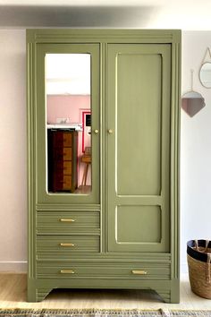 a green armoire sitting in the corner of a room