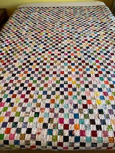 a multicolored quilt on top of a bed