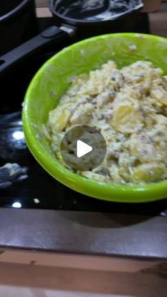 a green bowl filled with food on top of a stove