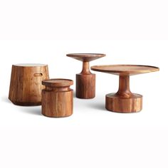 three wooden tables and two stools with one sitting on the floor, all made out of wood