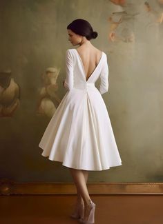 the back of a woman's white dress in front of a painting