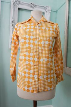 "gold and white check poly blouse huge lapels 24L x 18C Portrait Clothes b Barco lightweight, exc condition one button diff This authentic polyester 70s blouse is a mod gold and white checkered graphic, with huge long lapels. The fabric is in great condition, with no damage or issues. The bottom button is a little different. Please check measurements carefully. Condition: Excellent Vintage Tag: Portrait Clothes by Barco Measurements (taken flat) in inches.... Top of neck to bottom: 24 Across bac Cheap Gold Button-up Tops, Cheap Vintage Blouse With Button Closure, Cheap Yellow Vintage Blouse, Vintage Yellow Shirt For Work, 70s Blouse, Polyester Blouse, Vintage Cottage, Daytona Beach, Women Vintage