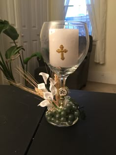 a wine glass with a cross on it sitting on a table