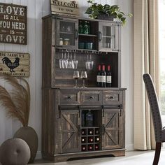 a wooden cabinet with wine glasses and bottles in it next to a dining room table