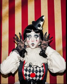 a woman with black and white makeup wearing a clown costume