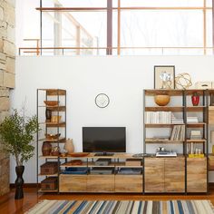 a living room filled with furniture and a flat screen tv on top of a wooden shelf