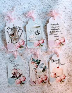 four tags with pink flowers and teapots are on the floor next to each other