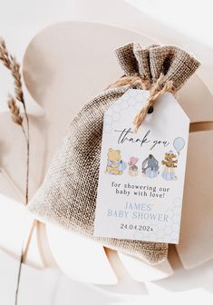 a baby shower gift bag with winnie the pooh tags attached to it's tag