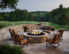 an outdoor fire pit with chairs around it