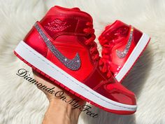 Bling Nike Air Jordan 1 Mid Shoes Hand Customized with Genuine Swarovski Crystals Colors: Patent Red & Matte Red w/ White Soles Model and Color Code: #DH5894-600 Note: Box may be missing top lid or shoe box Each and every Swarovski crystal is set by hand with top quality, permanent adhesive. Our products come direct from the manufacturer or authorized retailers, and are 100% authentic. We offer free crystal replacement for life! Should any crystals fall off, simply send your shoes back to us and Glitter Jordans Shoes, Luxury Nike Jordan Shoes With Red Sole, Luxury Red Jordan Shoes, Red Bling Nike Shoes, Nike Jordans Costom Colorful, Luxury Nike Sneakers With Red Sole, Luxury Red Custom Sneakers With Nonskid, Luxury Red Custom Sneakers For Women, Air Jordan 1 Diamond