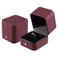 an open box with a wedding ring in it on a white background, the lid is closed