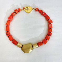 Small Coral beads in bright orange, combined with cylindrical metal matt gold color beads and an asymmetric matt gold color accent bead.  The bright orange and gold complement each other, and the cylindrical shape of the coral matches the shape of the metal beads.  The necklace is elegant and suitable for office attire or summer dresses.   The necklace is 17 inches long and weighs 4 ounces. Resin And Clay, Orange Necklace, Orange And Gold, Combination Of Colors, Color Beads, Orange Coral, Coral Necklace, The Coral, Brass Accents