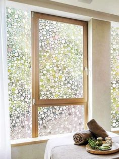 a bed sitting next to a window covered in white curtains