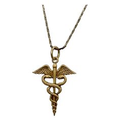 INDULGE IN A WONDERFUL CADUCEUS PENDANT WITH ENTWINED SNAKES IN 10 KARAT YELLOW GOLD. The caduceus is a symbol that features two snakes wrapped around a staff, often with wings, and is associated with medicine, Hermes, and peaceful dispute resolution. THE CADUCEUS IS OFTEN USED AS A SYMBOL FOR MEDICINE AND IS A WONDERFUL JEWEL FOR THE DOCTOR, NURSE, PA, MD, PHYSICIAN, AS WELL AS LOVERS OF GREEK MYTHOLOGY, AND PEACE AS WELL AS HERMES AND MERCURY, AND LOVERS OF SNAKE JEWELRY. And snake jewelry is all the rage - look at the photo of Naomi Watts from the Oscars I have included! The caduceus is the staff carried by Hermes in Greek mythology. It is a short staff entwined by two serpents, sometimes surmounted by wings. In Roman iconography, it was often depicted being carried in the left hand of Roman Iconography, Hermes Staff, Odd Items, Greek Necklace, Two Snakes, Victorian Pendant Necklace, Greek Mythology Jewelry, Dispute Resolution, Victorian Pendants