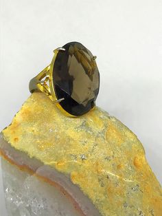 Beautiful large Smokey quartz cocktail ring. It features a gorgeous striking stone with a nicely detailed band. I'd estimate the age to be from the 1960's. Might be vermeil gold over silver as ring has some fading with gold. Ring does not have silver stamp. Size estimated to be an 8.5 to 9 woman's ring finger. Oval Gemstone Party Rings, Oval Gemstone Rings For Party, Elegant Yellow Gold Ring With Large Stone, Elegant Yellow Gold Rings With Large Stone, Luxury Faceted Crystal Ring For Anniversary, Elegant Citrine Crystal Ring, Elegant Citrine Crystal Ring With Gemstone, Elegant Collectible Ring With Large Stone, Elegant Collectible Rings With Large Stone