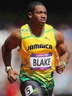 a male athlete in a yellow shirt and black shorts