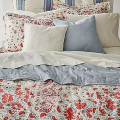 a bed with red, white and blue pillows on it