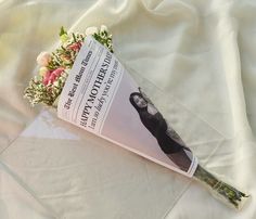 a book laying on top of a white sheet with flowers in front of the cover