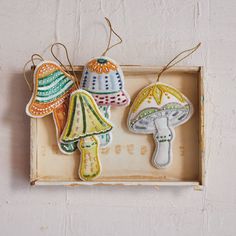 three embroidered mushrooms are hanging on the wall