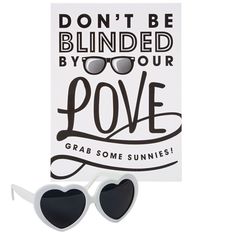 a pair of sunglasses sitting next to a sign that says don't be blinded by your love