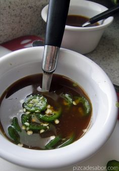 a white bowl filled with soup sitting on top of a table