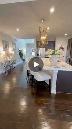 an open floor plan shows the kitchen and living room in this house with wood floors