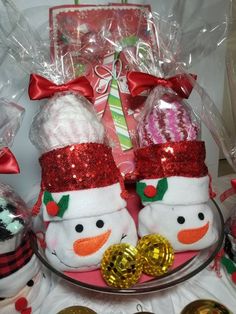 two snowmen are sitting in front of some christmas balls and candy canes on the table