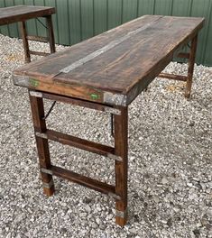 two wooden tables sitting on top of gravel