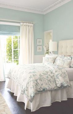 a bedroom with blue walls and white bedding