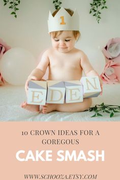 a baby wearing a crown sitting on top of a bed holding blocks with the words cake smash