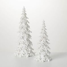 two white ceramic trees sitting on top of a table