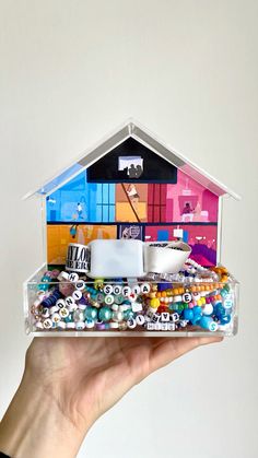 a person holding up a house made out of magnets