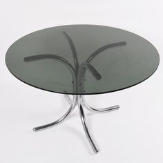 a round glass table with metal legs on a white background in the shape of a flower